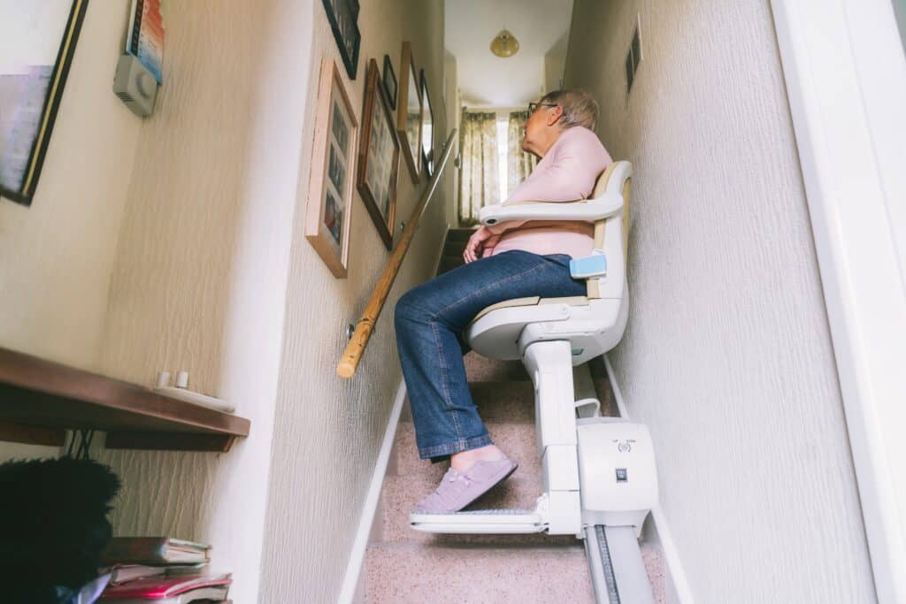 Senior woman using automatic stairlift on a staircase
